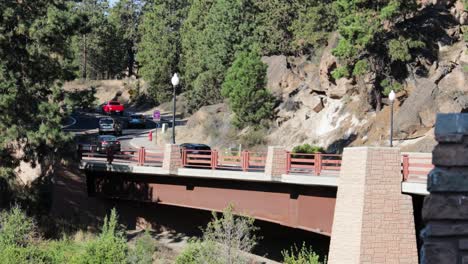 traffic crosses over a small bridge up towards a twisty mountain road