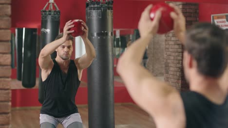 Deportista-En-Cuclillas-Con-Pelota-En-Forma-En-Un-Club-Saludable.-Deportista-Entrenando-En-Cuclillas