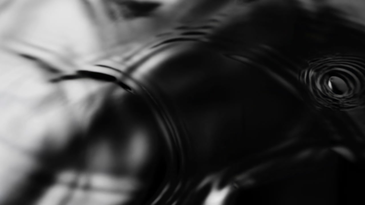 Black Water Surface With Ripples, Slowmotion Closeup Of Droplet Creating Concentric Waves, Glossy Reflections,
