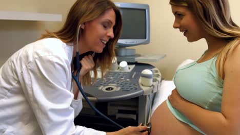 Doctor-using-a-stethoscope-on-a-pregnant-womans-stomach