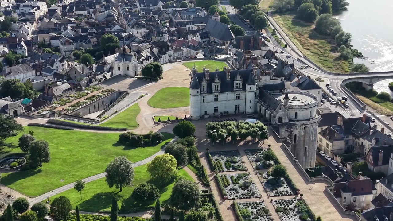 Vue aérienne cinématographique par drone du Château Royal d'Amboise surplombant la ville historique d'Amboise, présentant le château royal, la Chapelle Saint-Hubert, des jardins paysagers, la Loire