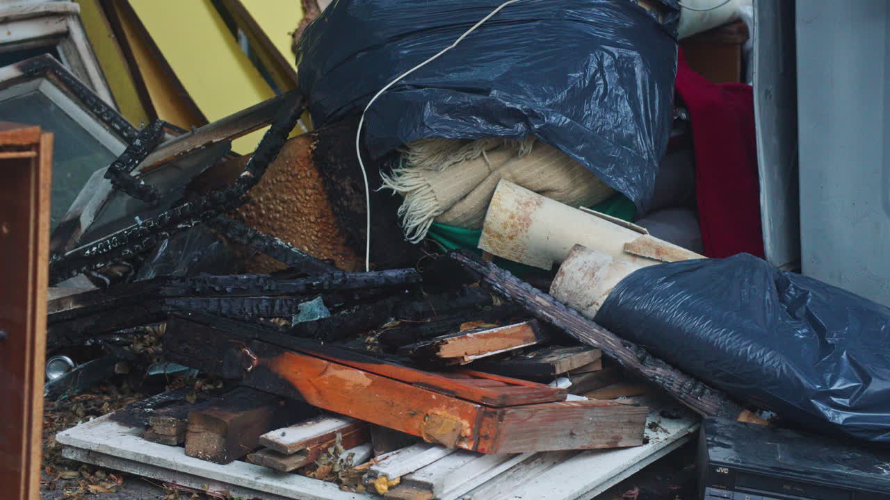 Abandoned construction materials, wood, furniture and burned frames and windows near a dumpster in Sofia, Bulgaria