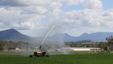 water cannon irrigating a large green field