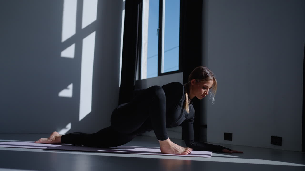 젊은 여성이 스튜디오에서 요가를 하고 있습니다.