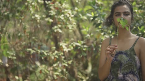 a young beautiful woman is planting a baby tree, standing in the sunlight in perfect harmony with nature