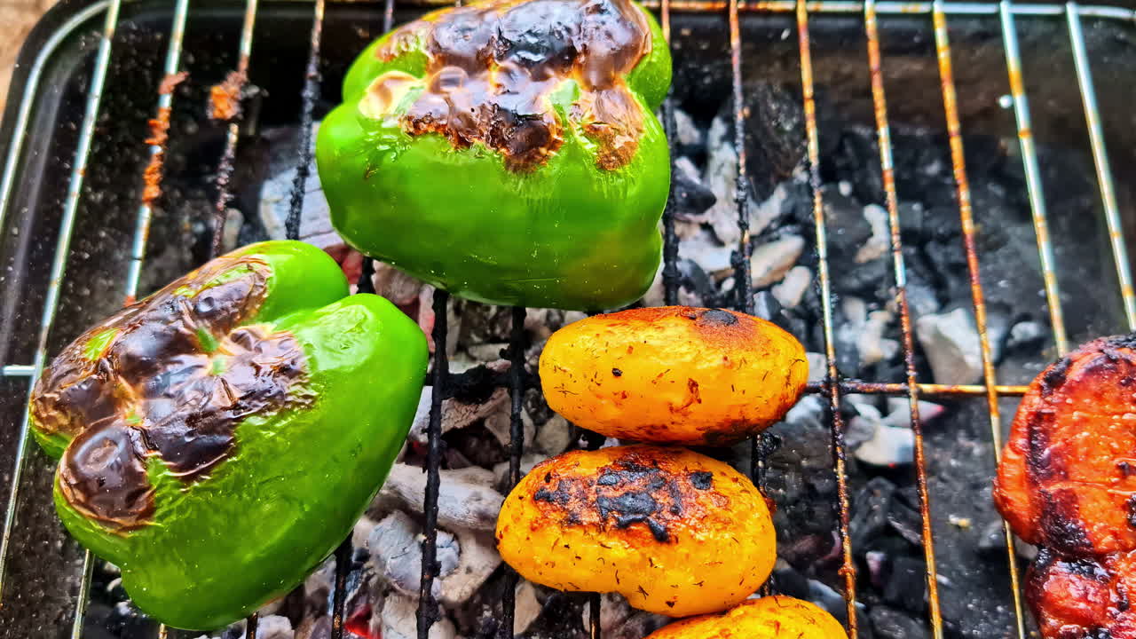 Tasty grilled vegetables and meat rest on a hot grill during a camping day