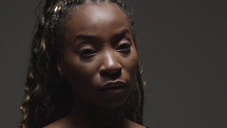 Retrato de belleza de cabeza y hombros de mujer joven sobre fondo de estudio gris 1