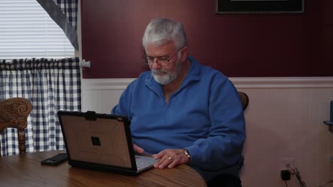 senior citizen happy using a computer and technology to do daily activities