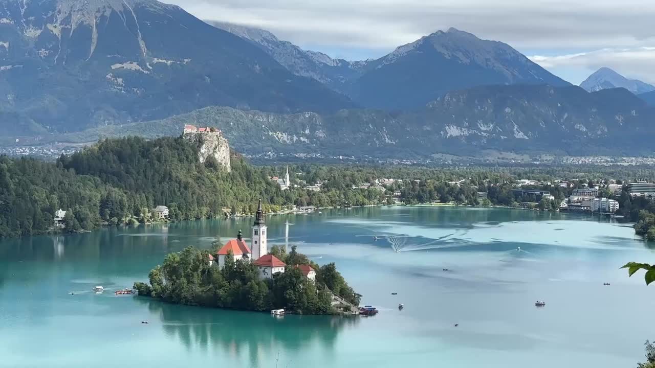 Static shot of Lake Bled in Slovenia, featuring the iconic island church, turquoise waters, and surrounding alpine mountains