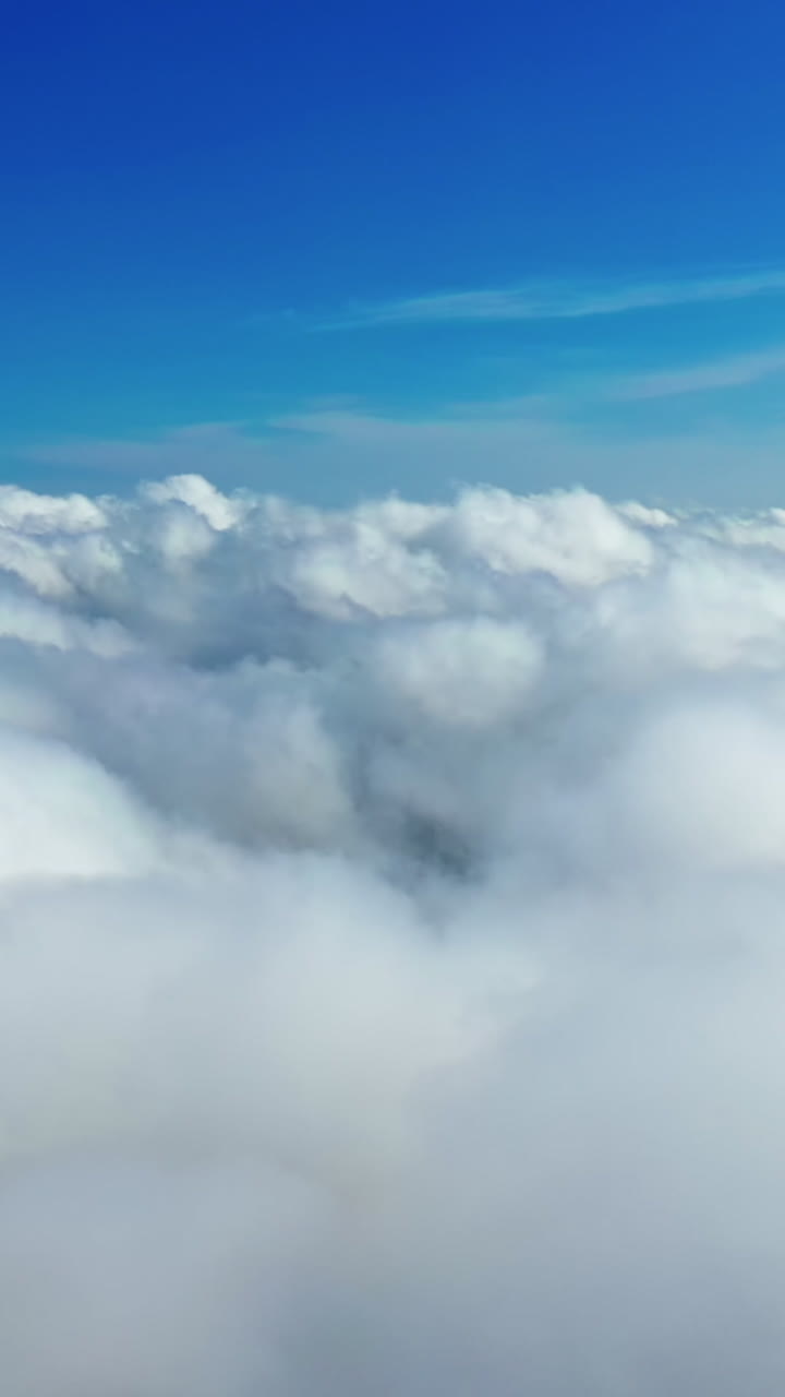 Beautiful white clouds in the air. Panoramic view of blue sky with soft clouds background. Amazing cloudscape. Aerial view. Vertical video