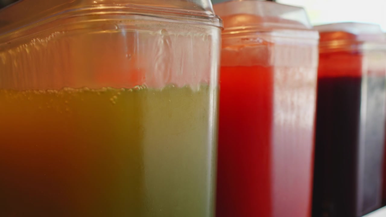 Colorful Fresh Juice Dispensers in a Row Close-Up