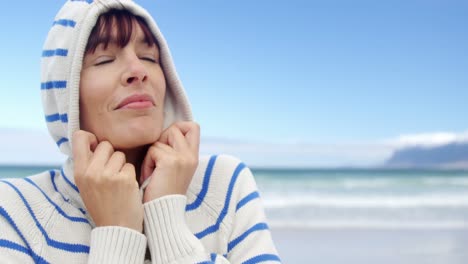 mujer con capucha en la playa