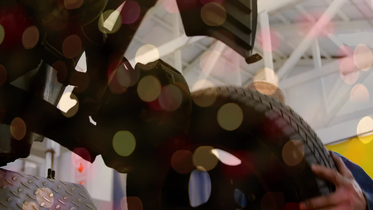 Mechanic adjusting car wheel in repair garage, with animated overlays showing lift data