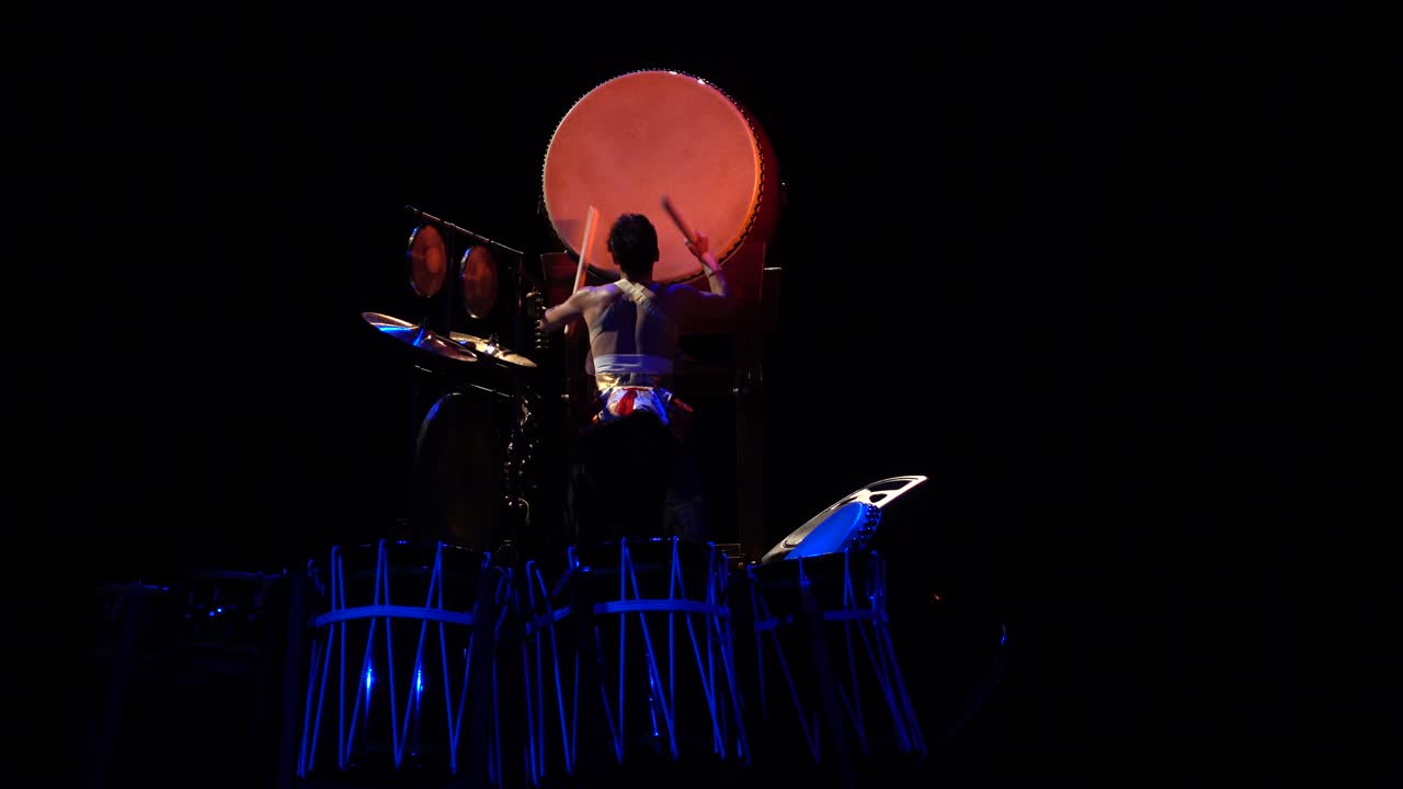 Japansk trommeslager fremfører tradisjonell Taiko-tromme på scene