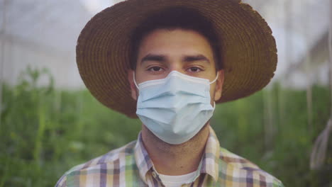 farmer in a greenhouse wearing a face mask