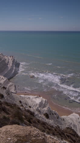 the beautiful white cliff steps of scala dei turchi beach in sicily in vertical