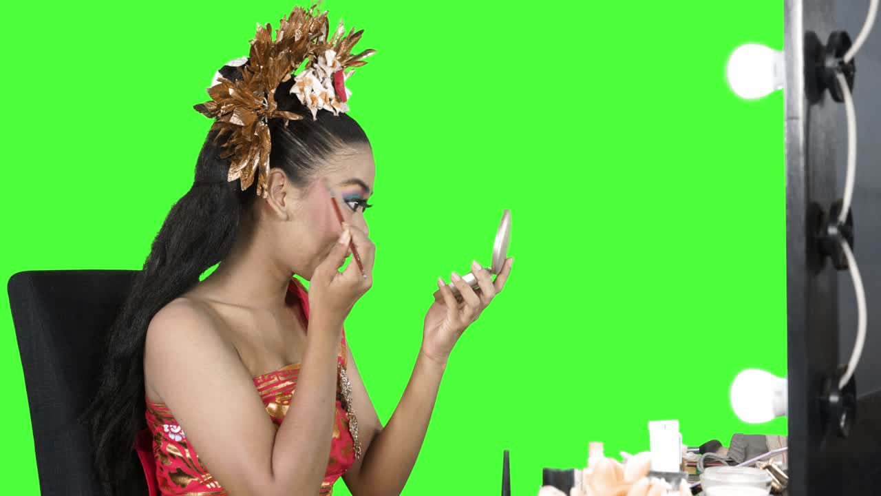 Danzatrice balinese che si trucca il viso