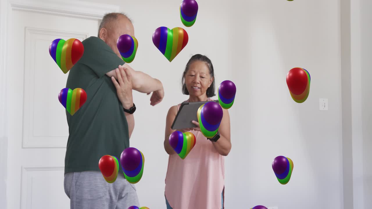 Senior woman tapping tablet starting man stretching arm for health while AR hearts floating around