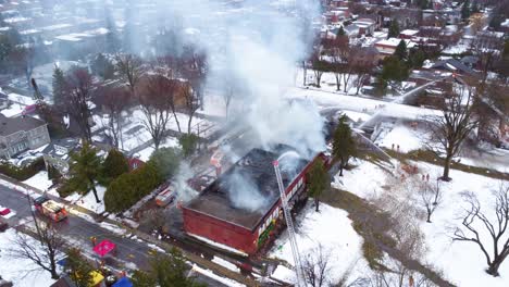 convoy of fire trucks blocking road to extinguish large red building