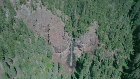 drone view of a small waterfall on a cliff in colorado rocky mountains