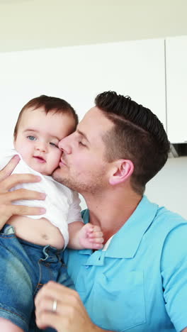 father lifting up and playing with his baby boy