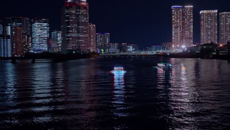 Luz-Nocturna-Tokio,-Tsukuda,-Rascacielos-Toyosu-Y-Puente-Sobre-El-Río-Sumida-Yakatabune,-Embarcación-De-Recreo