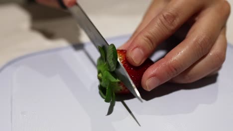 slicing a strawberry with a knife