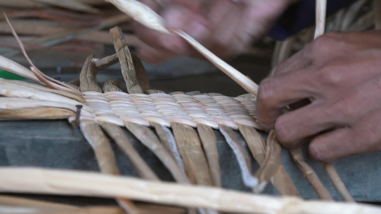 Close Shot of a Woman Weaving Palm Tree Leaf