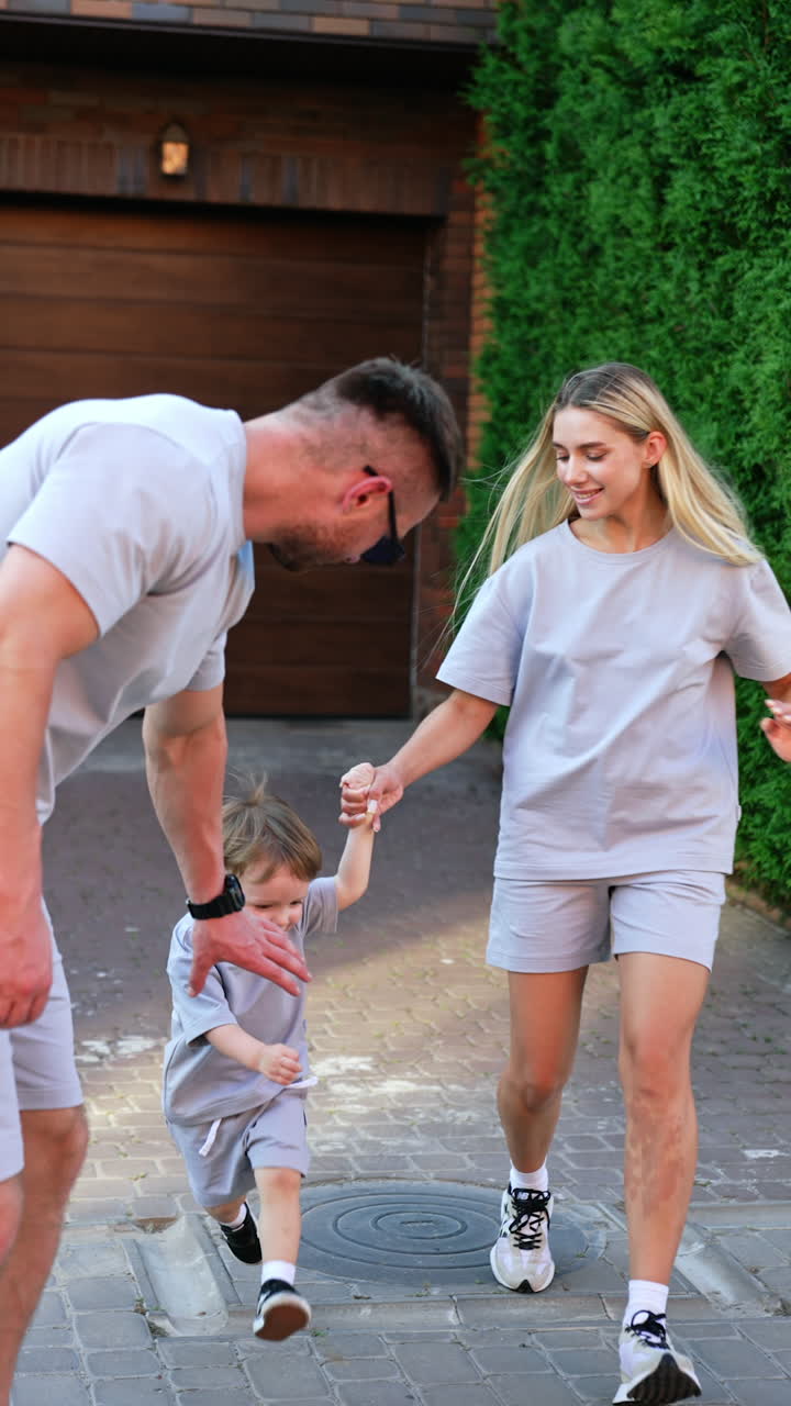 Kyiv, Ukraine, 25 May 2025: Family outing on a sunny day in the city. A man stands casually with hands in pockets as a woman and child walk behind him, enjoying a sunny day outdoors