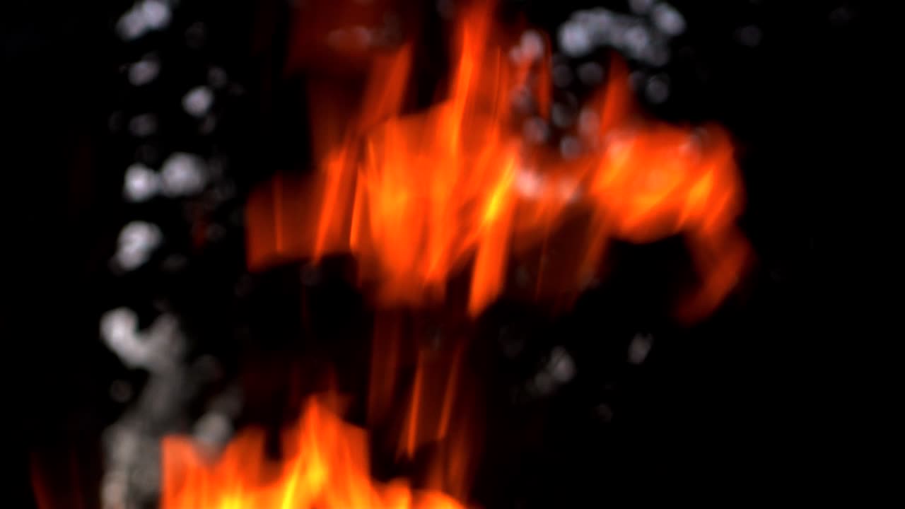 Fiamma del fuoco su sfondo nero. Fuoco nell'oscurità. Slow motion
