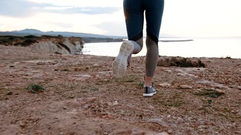 woman doing cross country running on cliff by the sea