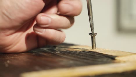 static man removing a bent screw with a screw driver