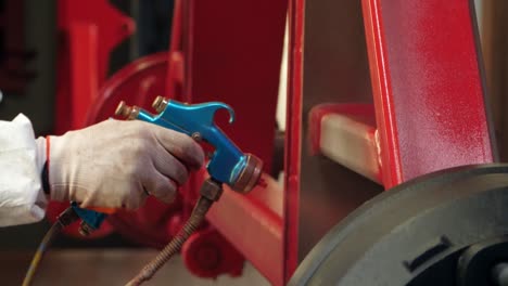 female worker using spray gun under pressure. woman painting metal details