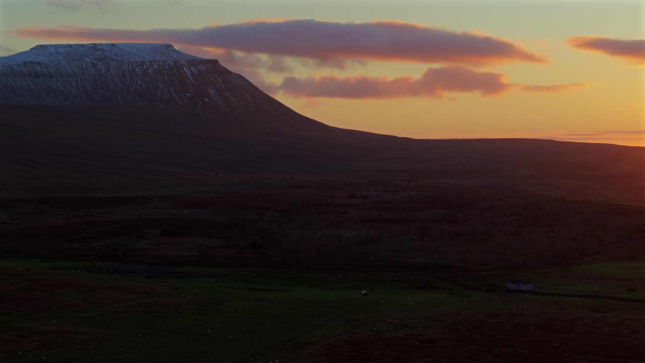 estableciendo una toma de avión no tripulado de las nevadas valles de ingleborough yorkshire al atardecer