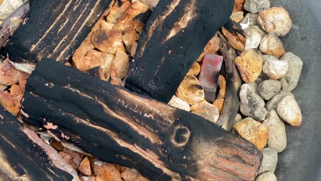 an unlit bonfire in an outdoor fireplace