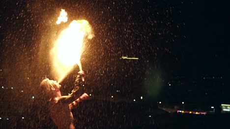 young blond male breathes out large stream of fire multiple times slow motion shot