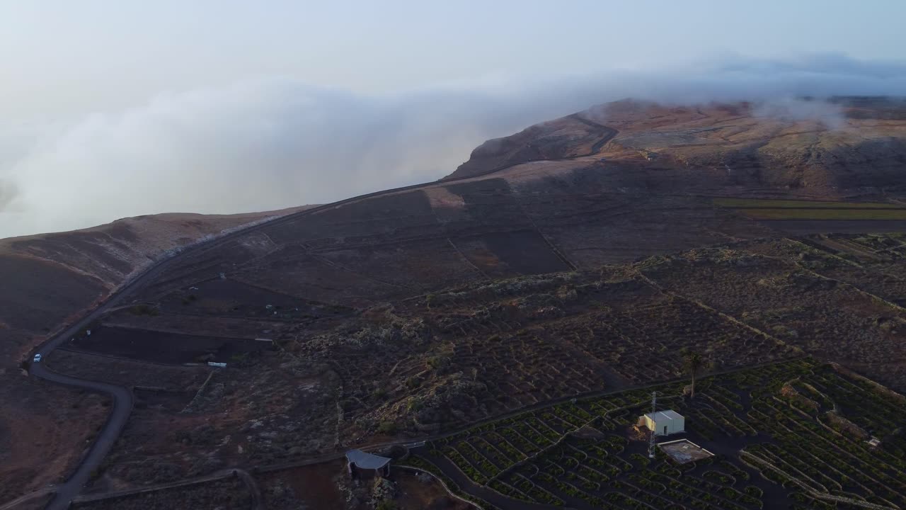 White Car Driving At The Mountain Pass In Volcan De La Corona At  Lanzarote, Spain. aerial