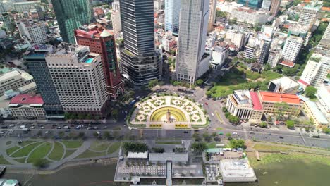 Zoom-Aéreo-Fuera-Del-Tráfico-Conduciendo-A-Través-De-Una-Rotonda-En-El-Distrito-1-De-La-Ciudad-De-Ho-Chi-Minh-Vietnam-En-Un-Día-Soleado