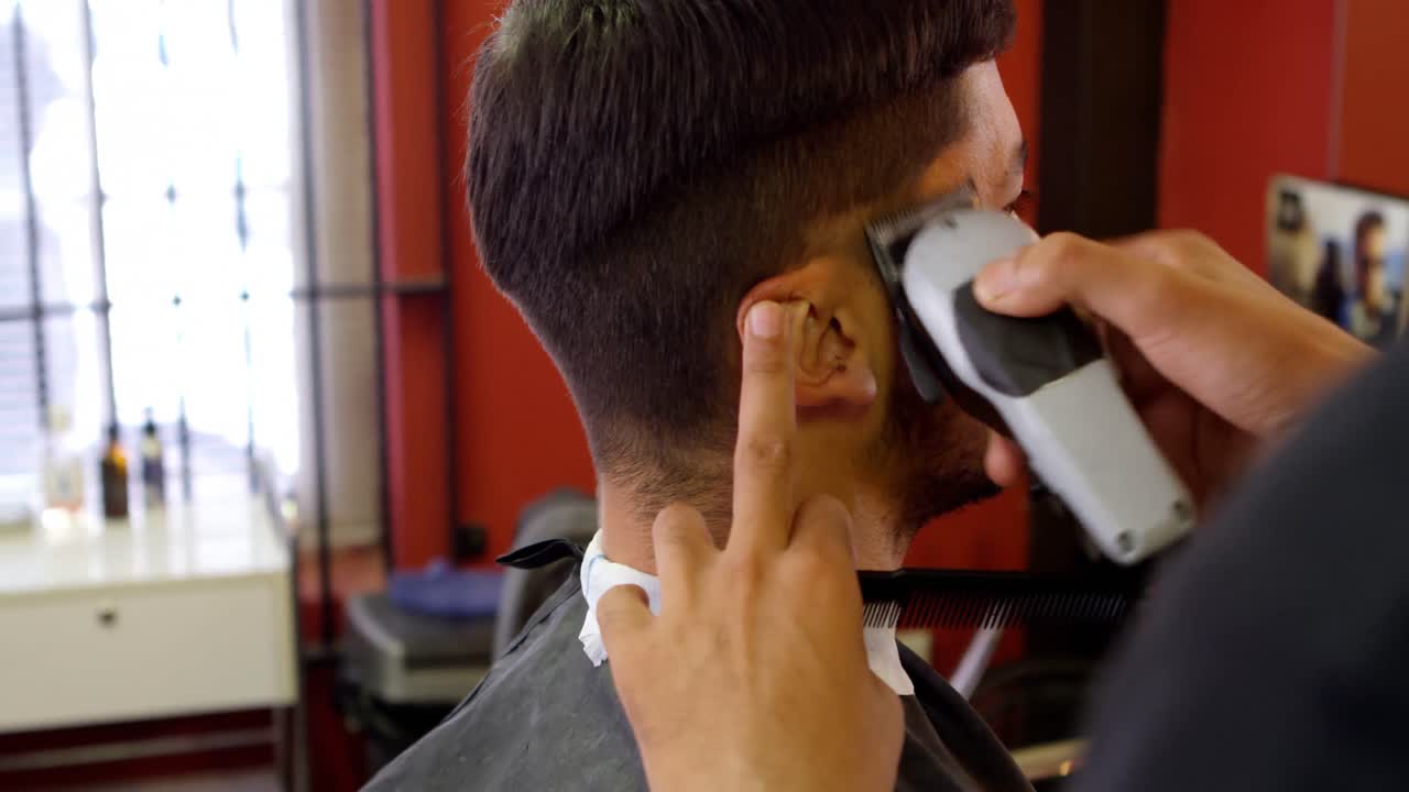 hombre recibiendo su cabello recortado con trimmer 4k
