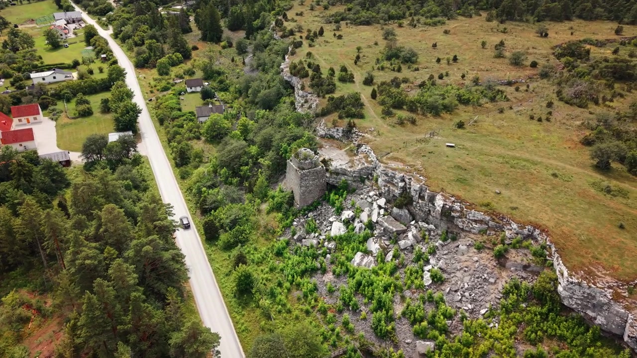Gotland, İsveç'te sakin bir köy yolunun kenarında duran eski taş fırın kalıntıları, adanın endüstriyel mirasını kırsal bir kıyı manzarasında ortaya koyuyor