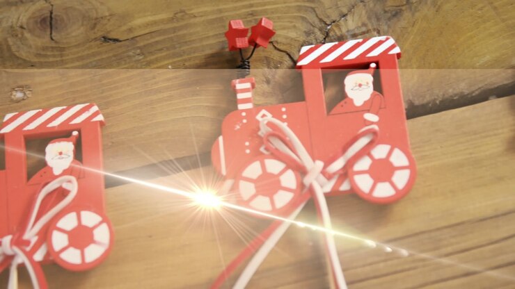 Animation of light moving over christmas train decorations on wooden surface