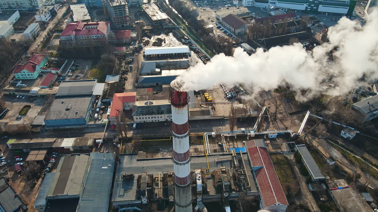 Aerial drone view of Chisinau. Thermal station with smoke coming out of the tube. Buildings, roads and bare trees. Good weather. Moldova
