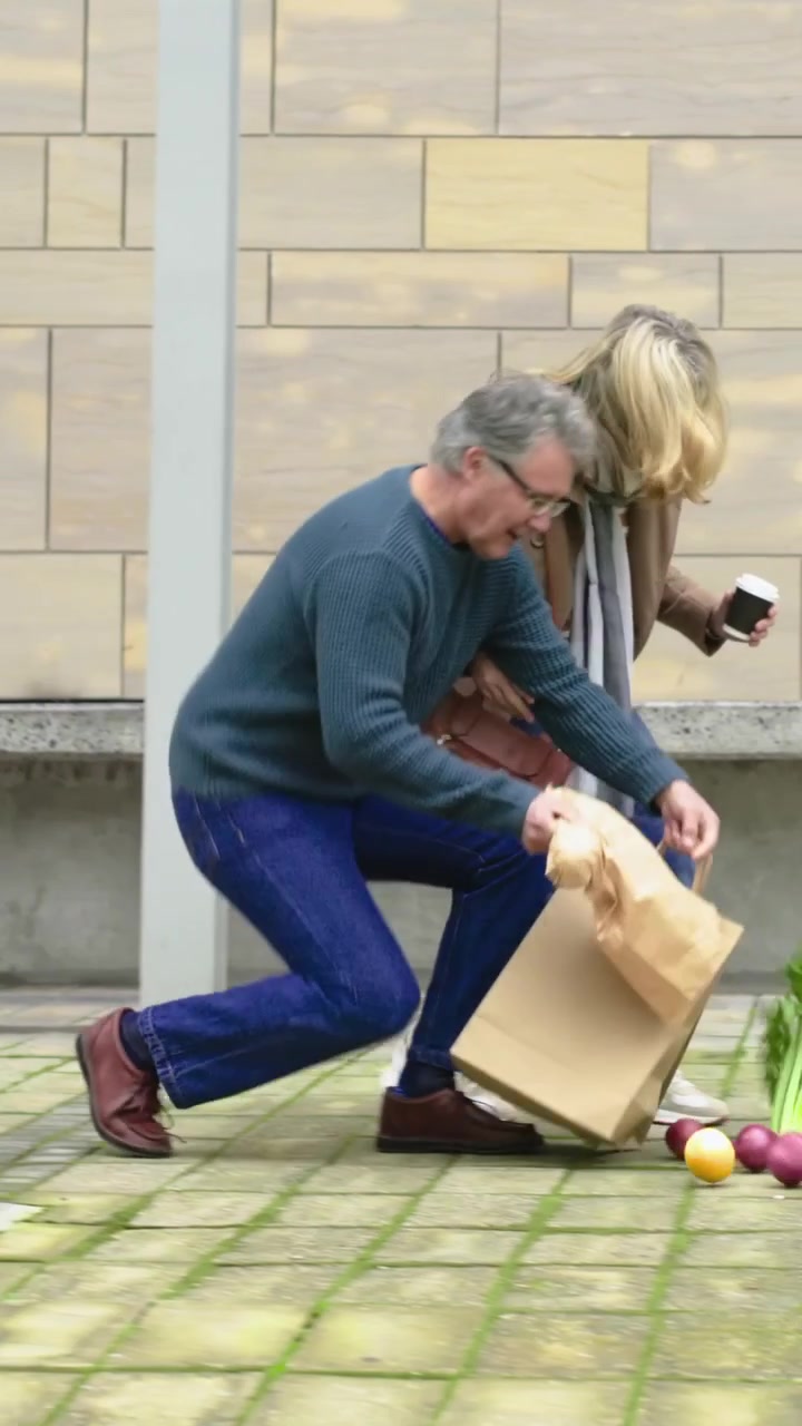 Vertical video: Picking food after bag shifting, man in sweater saving bags, woman with cup in yard
