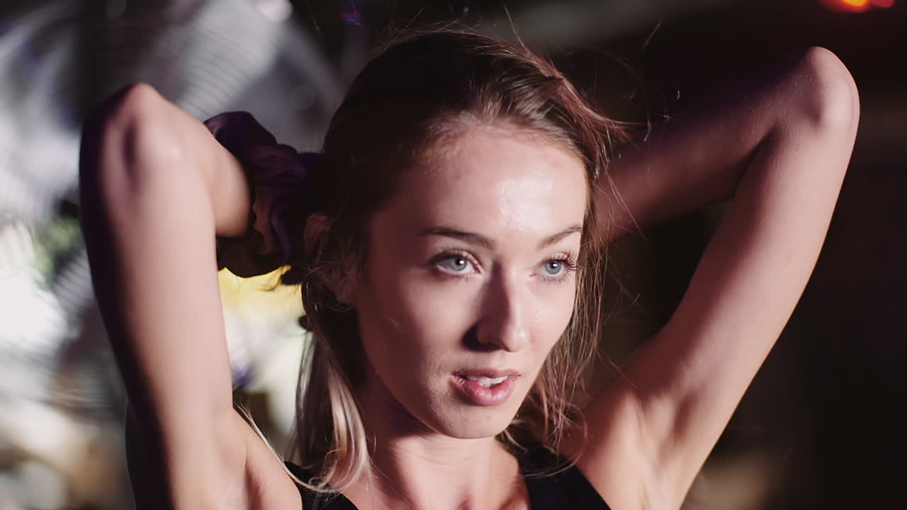 cámara lenta de atleta femenina atractiva sonriente moviendo las manos a través del cabello en el club de salud 5