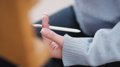 Close-Up-Of-Artist-Holding-Charcoal-Sitting-At-Easel-And-Working