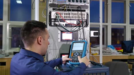 técnico de red que trabaja con equipos de red y osciloscopio