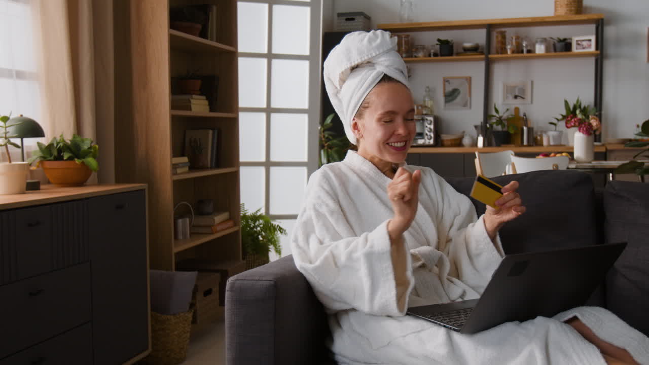 Woman in bathrobe shopping online with credit card