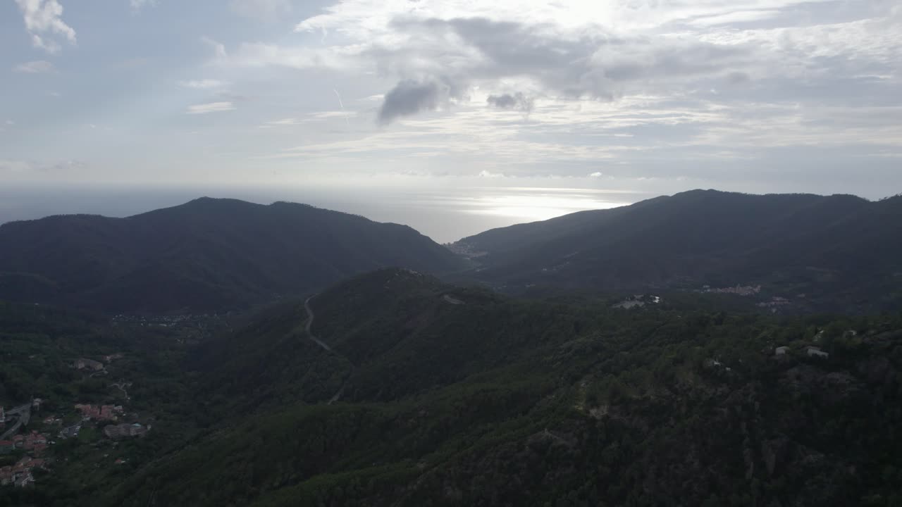 fascinante video grabado sobre los pinos voladores del paso de bracco en italia, en el fondo el mar y la playa de deiva marina