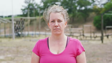 mujer caucásica mirando a la cámara en el campo de entrenamiento