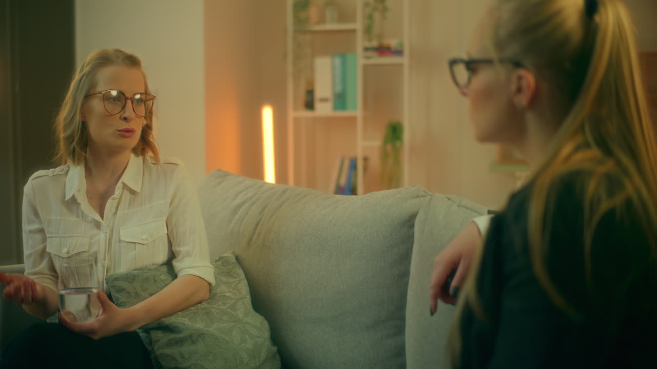 To kvinder diskuterer problemer under en krise på sofaen.